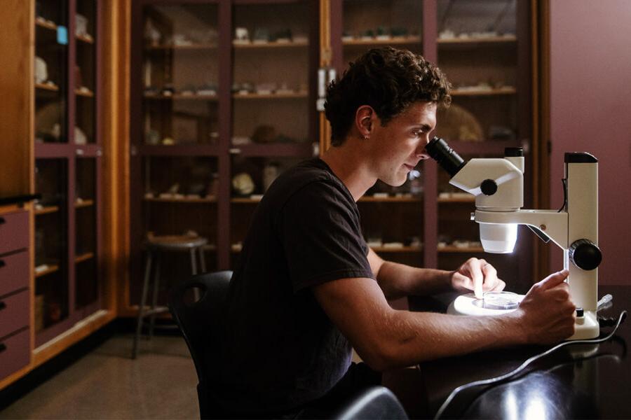 Biology student looks into a microscope.