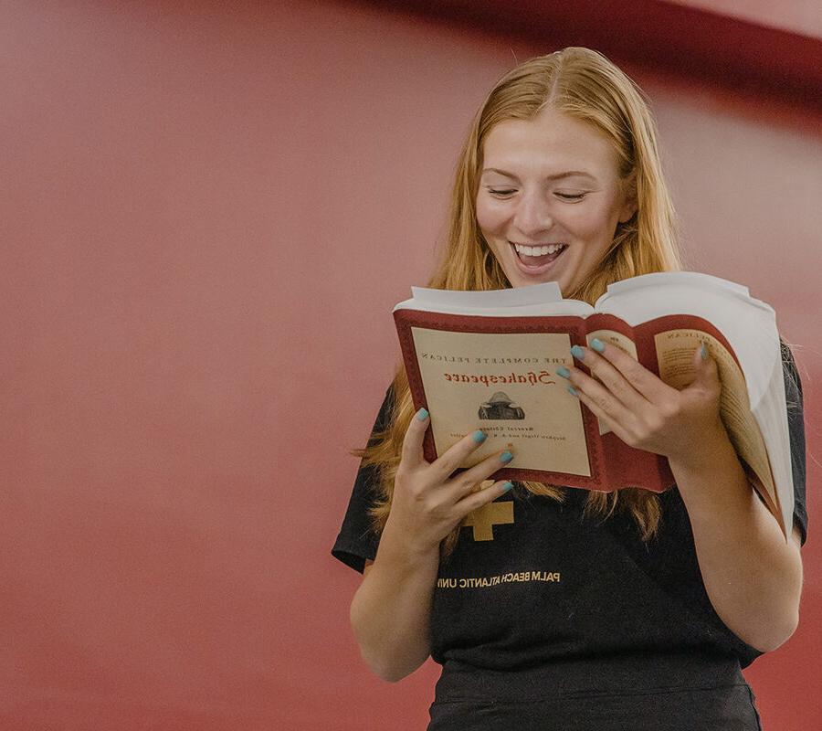 A student reading a book and smiling