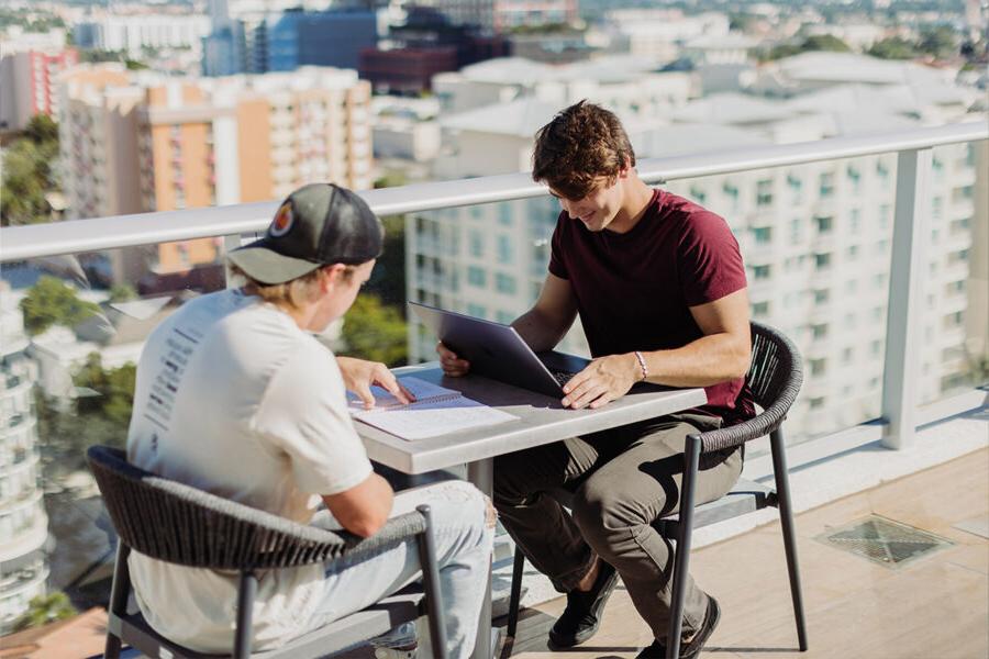 Two PBA students study on a rooftop.